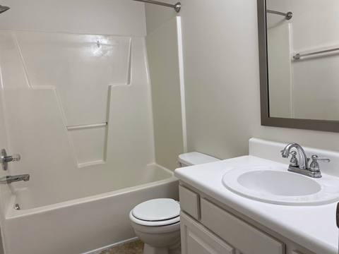 A bathroom with a sink toilet and bathtub.