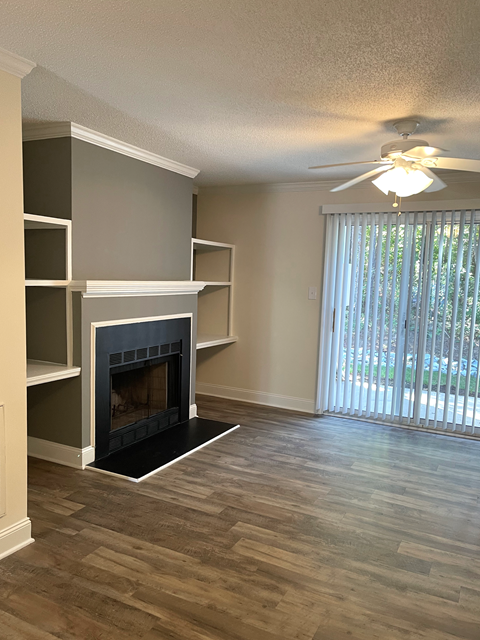 a empty living room with a fireplace and shelves