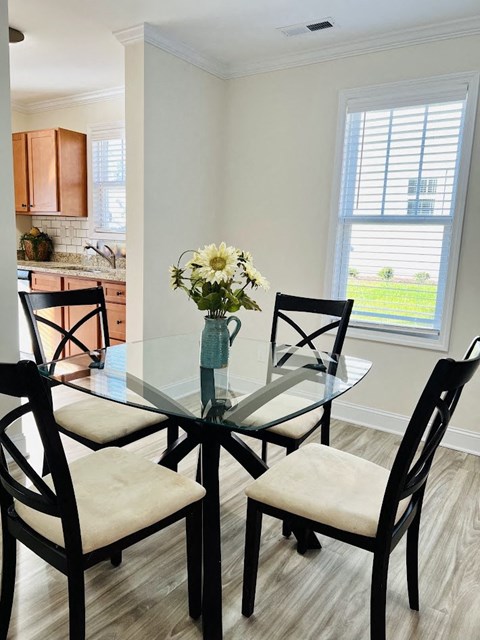 a dining room table with a vase of flowers on it
