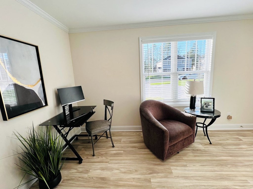 a living room with a chair and a table and a window