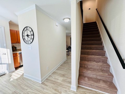 a staircase with a clock on the wall next to a house