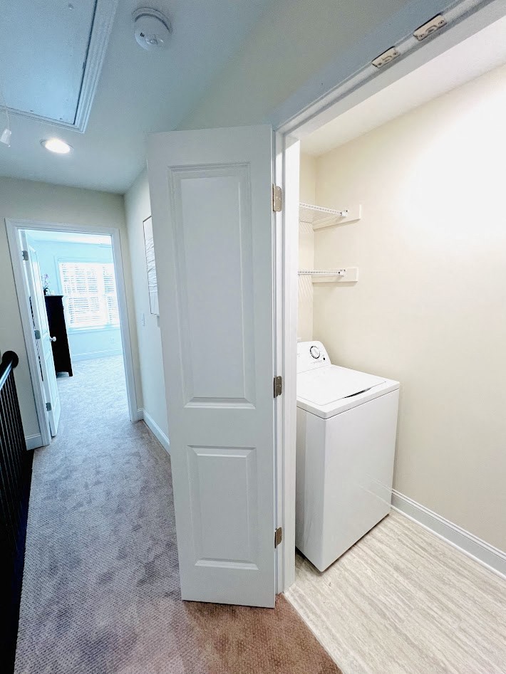 a laundry room with a washer and dryer and a white door
