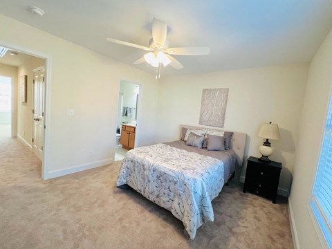 a bedroom with a bed and a ceiling fan