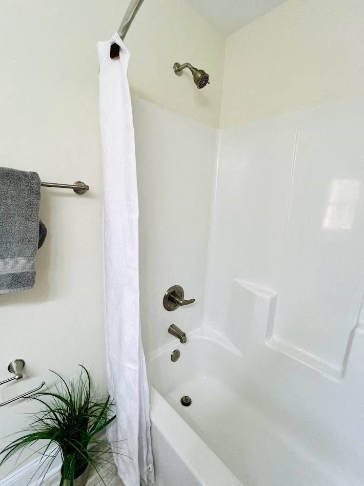 a bathroom with a white tub and a white shower curtain