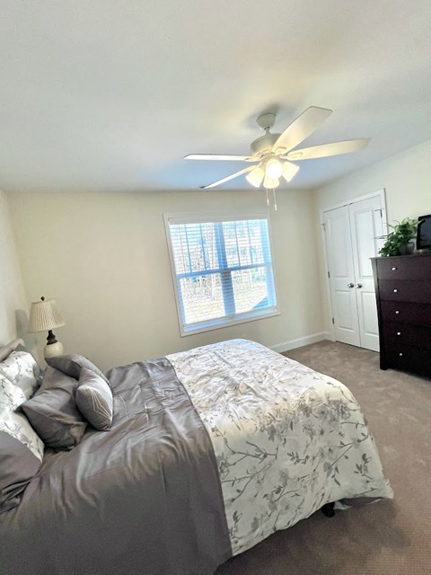 a bedroom with a bed and a ceiling fan