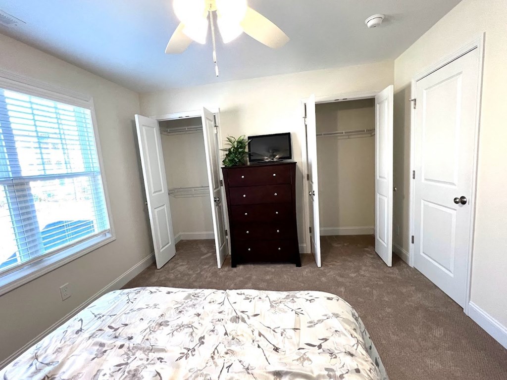a bedroom with a bed and a dresser and a window