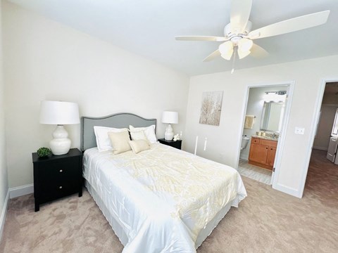 a bedroom with a large bed and a ceiling fan