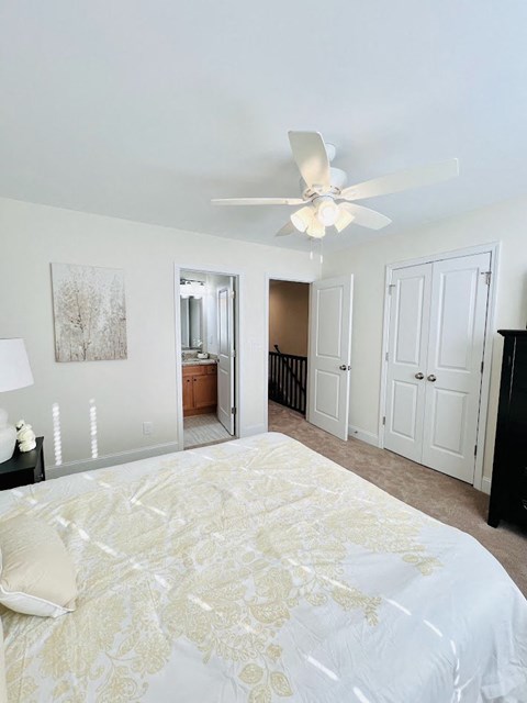 a bedroom with a large bed and a ceiling fan
