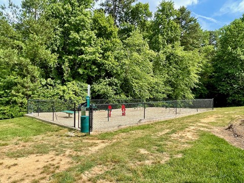 two children playing tennis on a court in a park