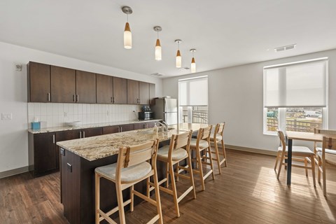 A kitchen with wooden chairs and a granite counter.