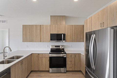 A modern kitchen with wooden cabinets and stainless steel appliances.