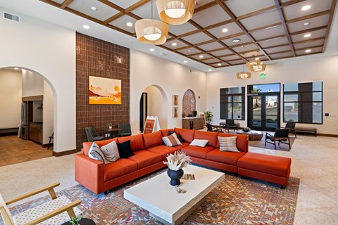 A living room with a red couch and a white coffee table.