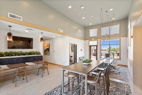 A modern dining room with a long table and chairs.