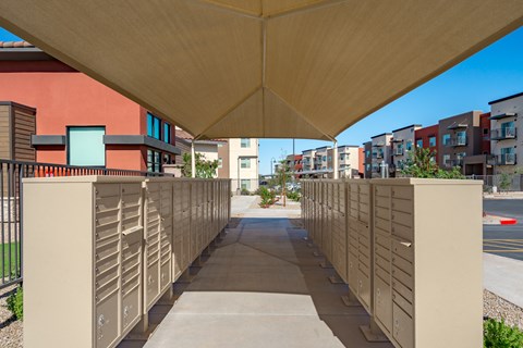 A long concrete walkway with a roof and a metal fence on the left side.