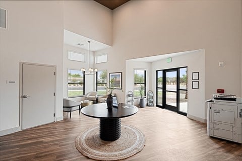 A modern living room with a black coffee table in the center.