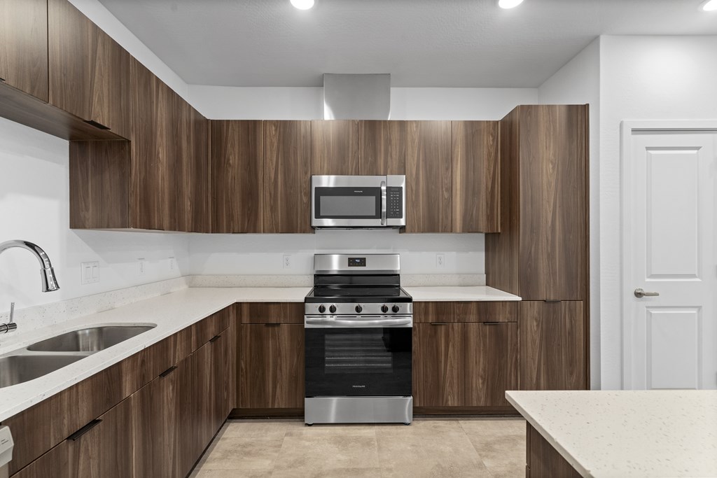 A modern kitchen with wooden cabinets and stainless steel appliances.