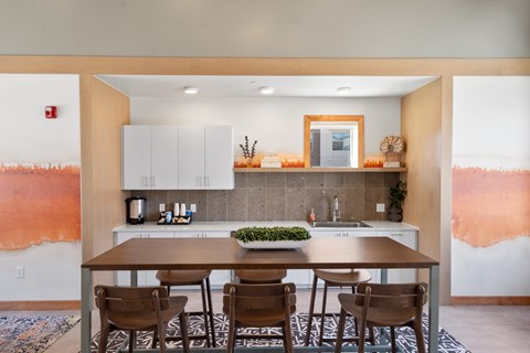 A kitchen with a table and chairs in front of it.