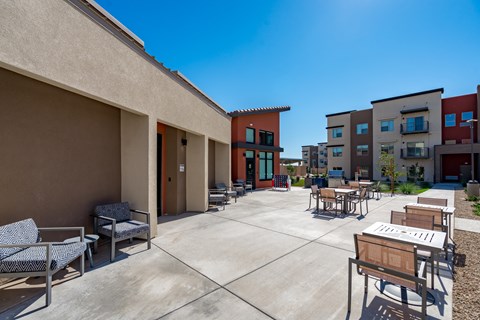 A sunny day at a courtyard with a table and chairs.