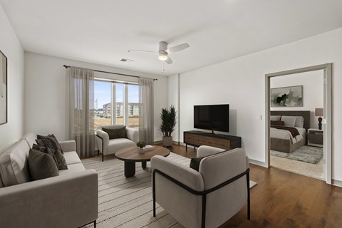A living room with a grey couch, a coffee table, and a television.
