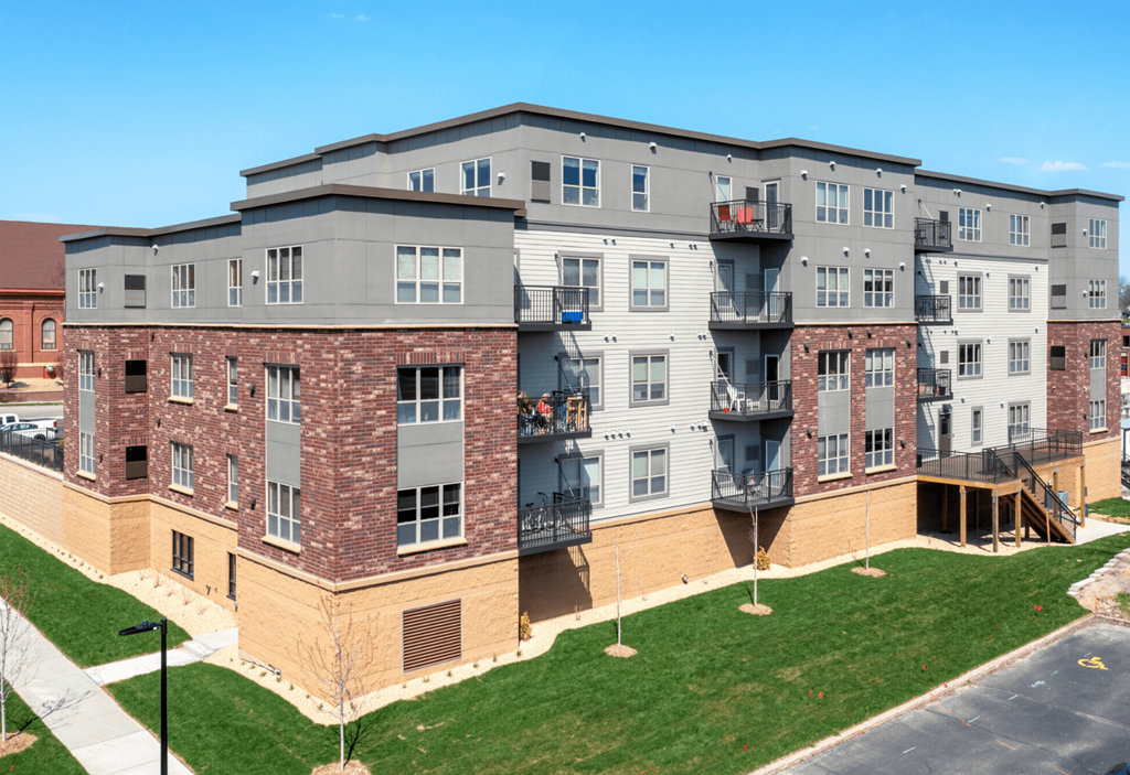 an aerial view of an apartment building with green grass