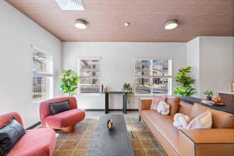 A living room with a red chair and a brown couch.