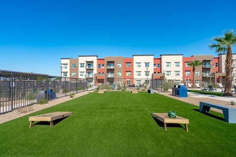 A grassy area with benches in front of apartment buildings.