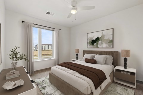 A bedroom with a large bed and a ceiling fan.