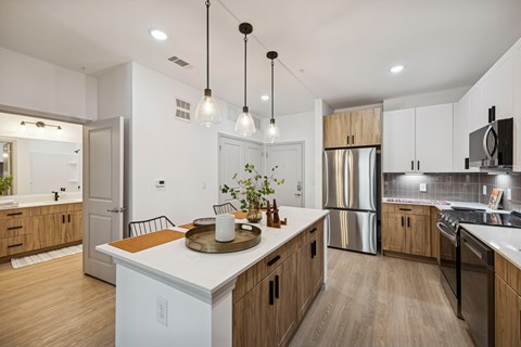 A modern kitchen with wooden cabinets and stainless steel appliances.