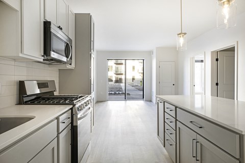 A modern kitchen with white cabinets and appliances.