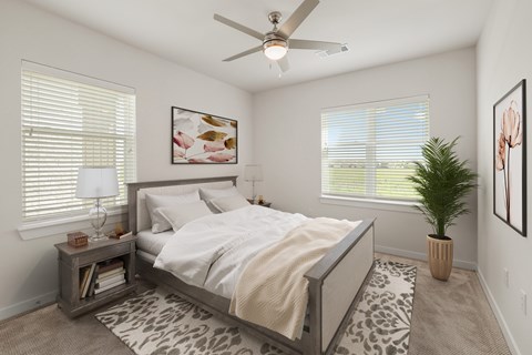 A bedroom with a bed, a ceiling fan, and a potted plant at The Narrows in Hutto, TX.