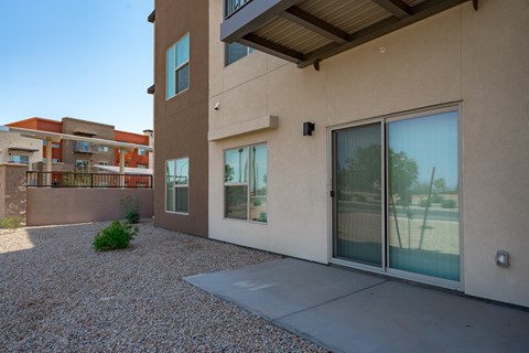 A modern house with a gravel driveway and a clear blue sky.