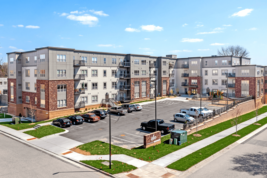 an aerial view of an empty parking lot in front of an apartment building