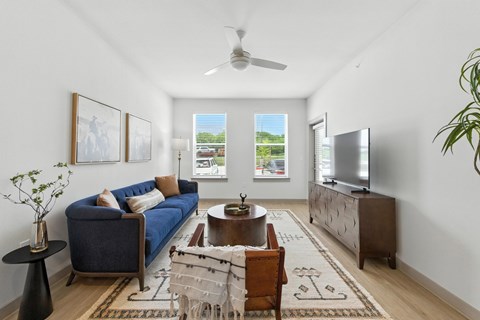 A living room with a blue couch, a coffee table, and a television.
