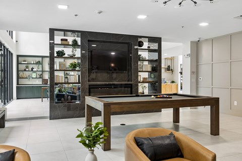 A modern living room with a pool table and a fireplace.