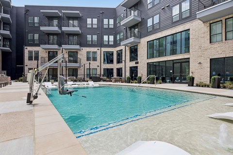Luxury outdoor swimming pool at The Elara in Farmers Branch, TX with resort-inspired design and poolside loungers near Dallas