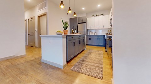 A kitchen with a white counter and blue cabinets.