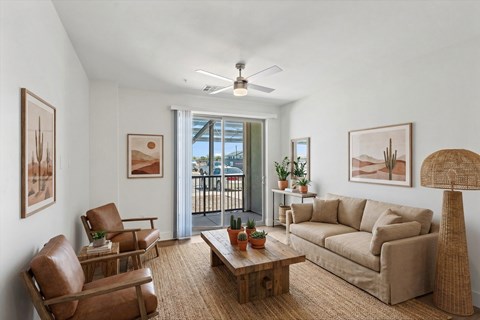 A living room with a brown sofa, two chairs, and a coffee table.
