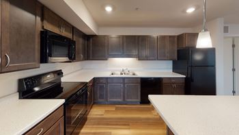 a kitchen with dark wood cabinets and white countertops