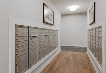 A hallway with a row of mailboxes on the wall.