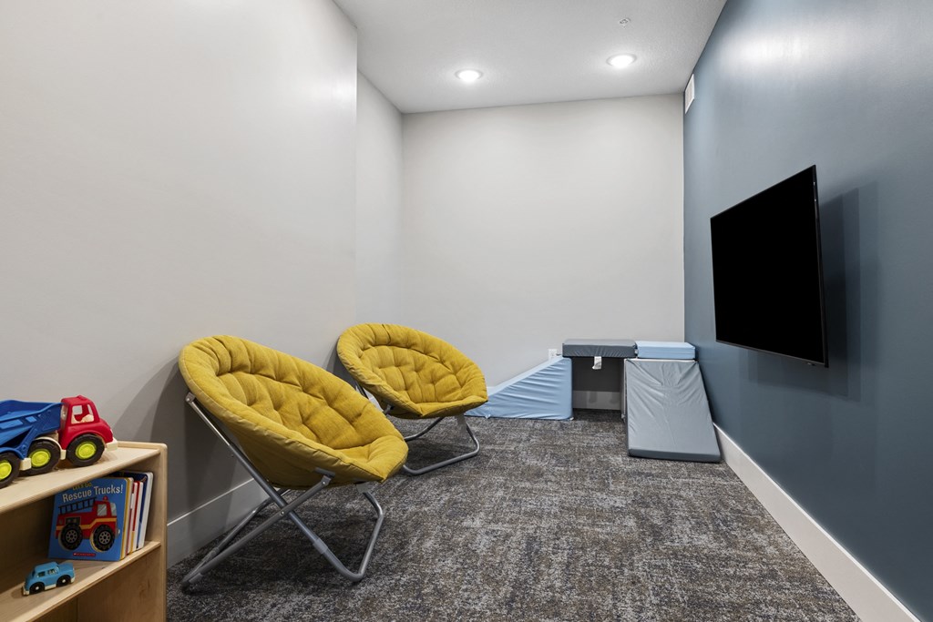 a room with two chairs and a tv on the wall