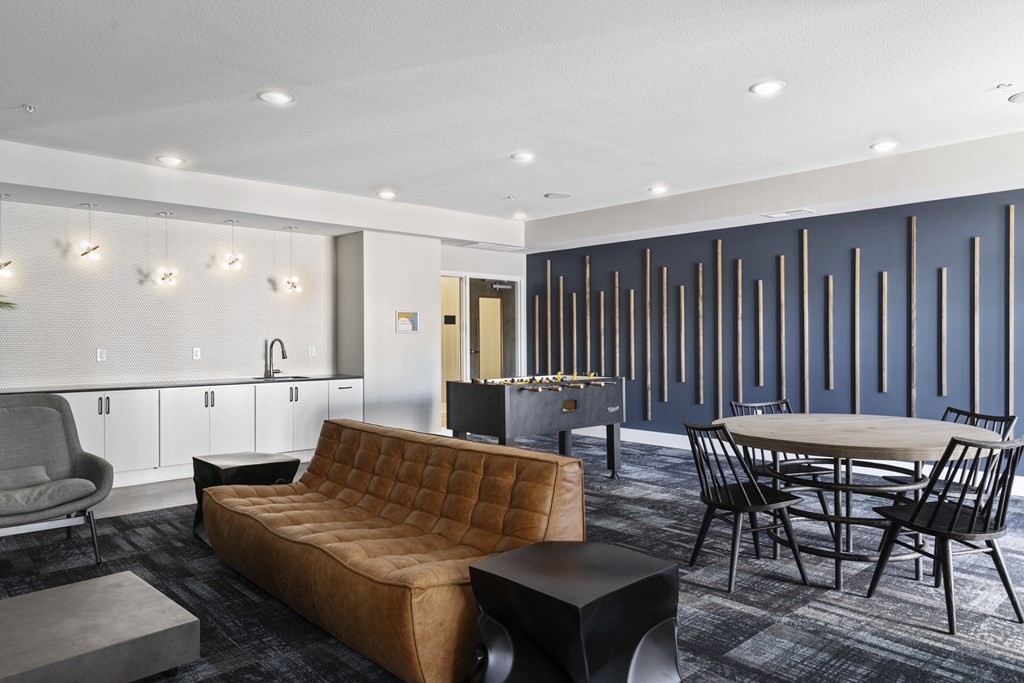 a clubhouse with a couch and a table and chairs