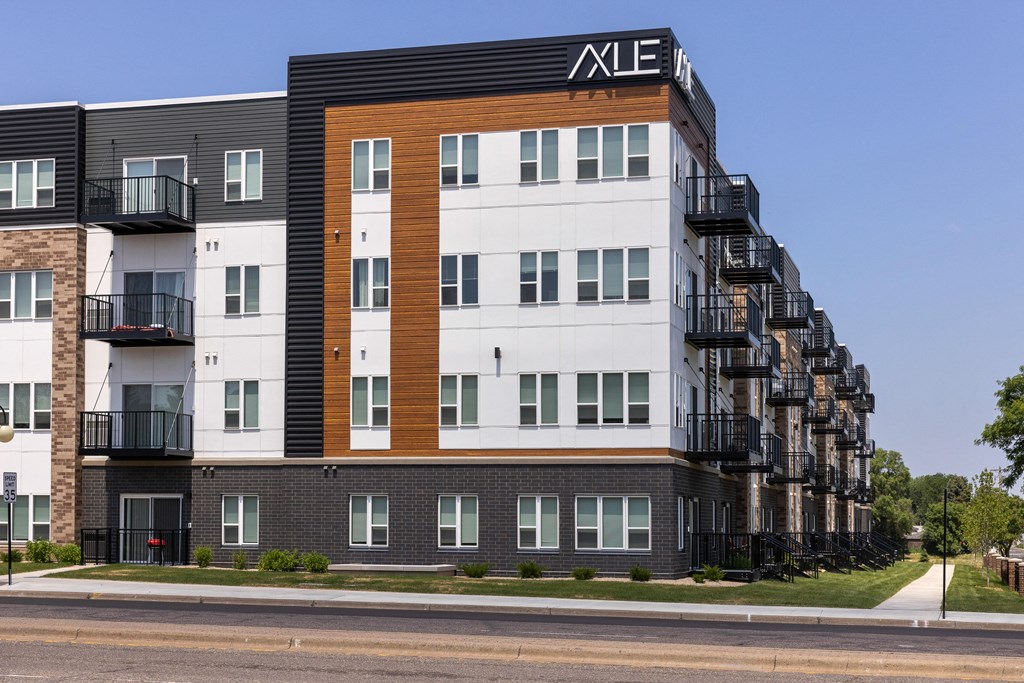 a tall apartment building with balconies and a sign on top of it