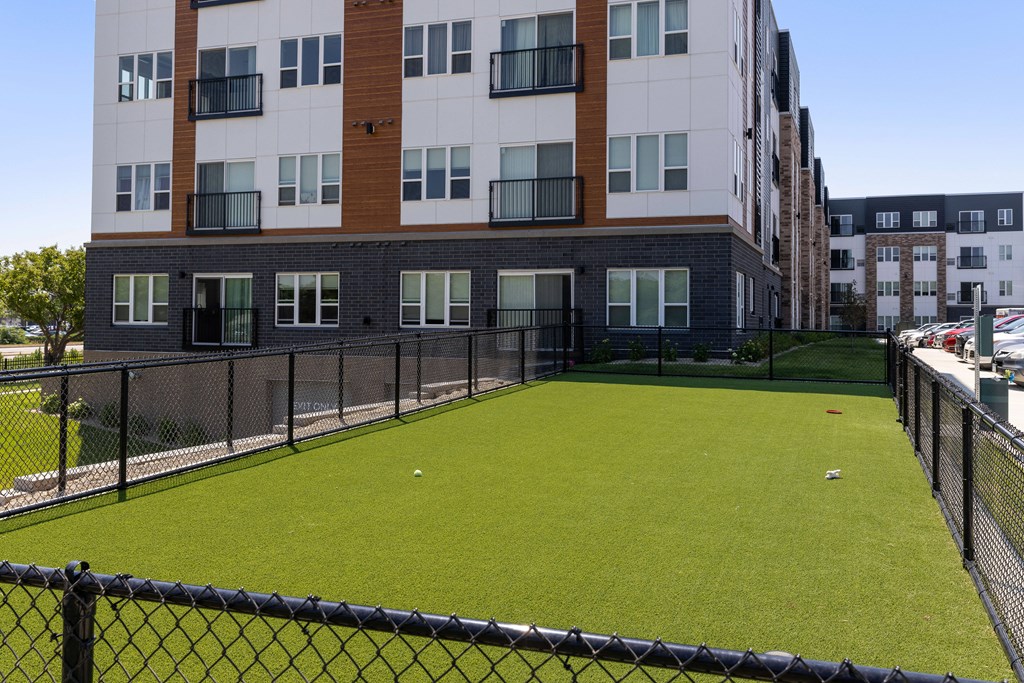 an apartment building with a green lawn in front of it