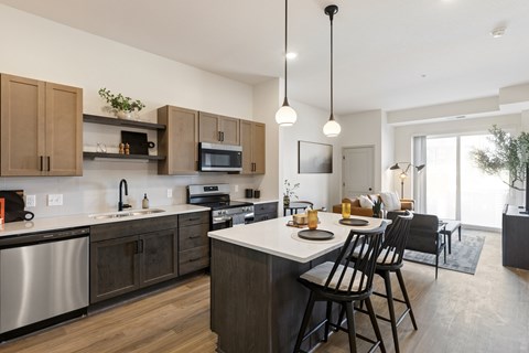 A modern kitchen with dark wood cabinets and stainless steel appliances.
