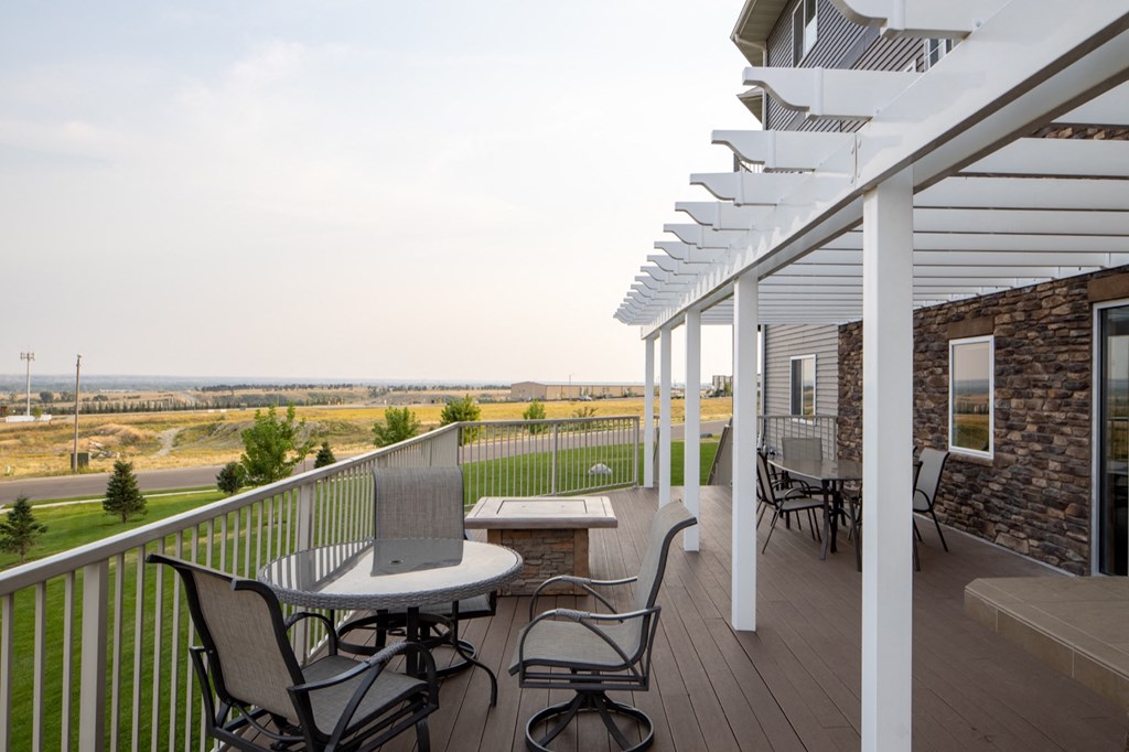 a patio with a table and chairs on a porch