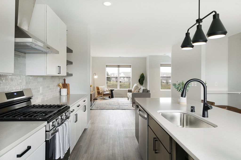 a kitchen with white cabinets and a sink and a counter top