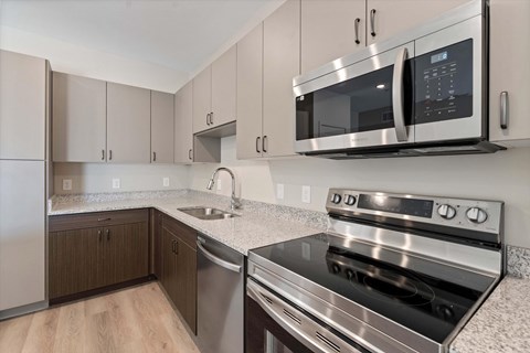 A modern kitchen with a stainless steel oven and microwave.