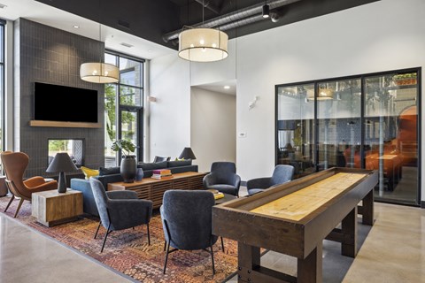 A modern living room with a wooden table and grey chairs.