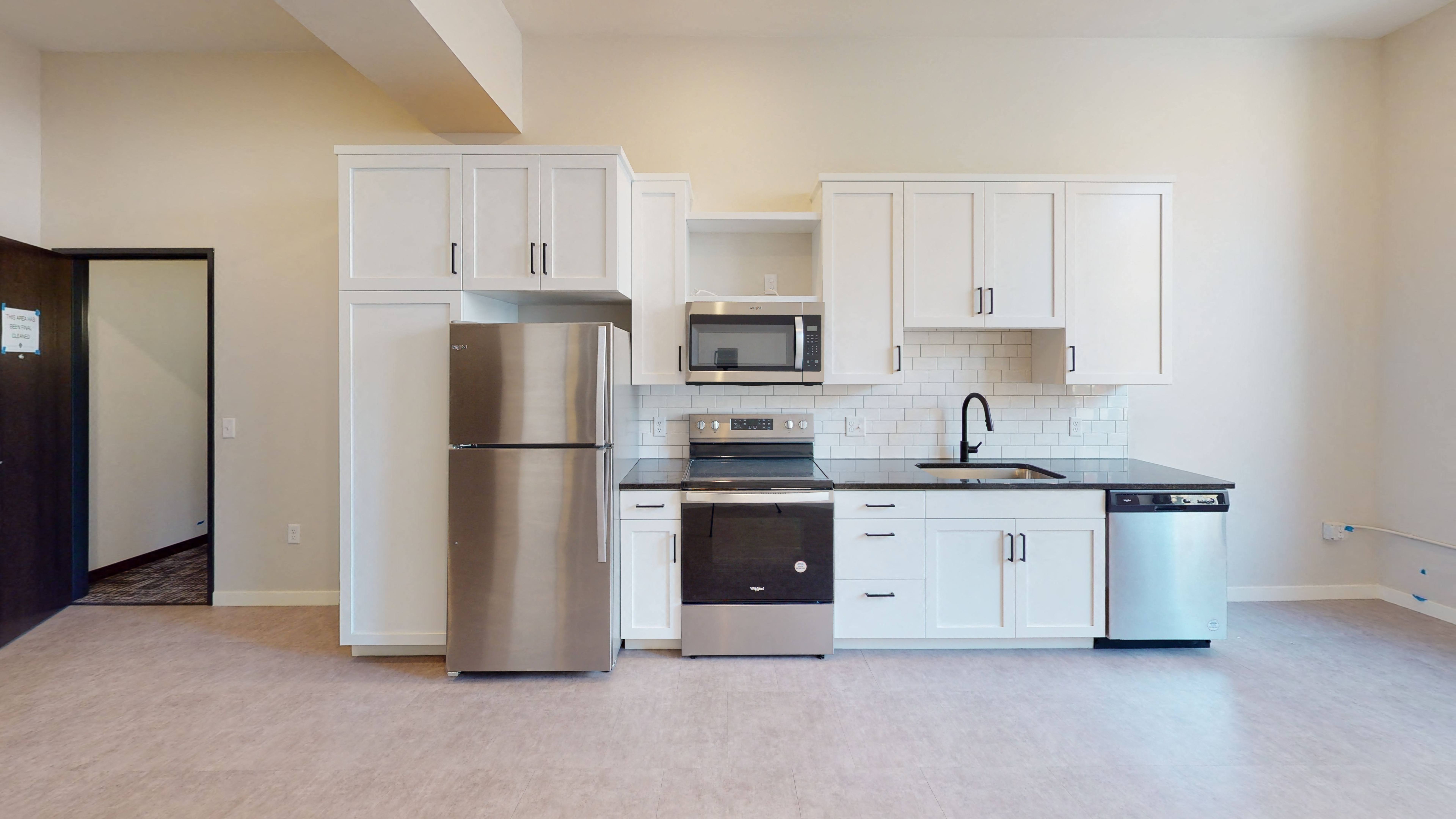 A kitchen with white cabinets and stainless steel appliances.