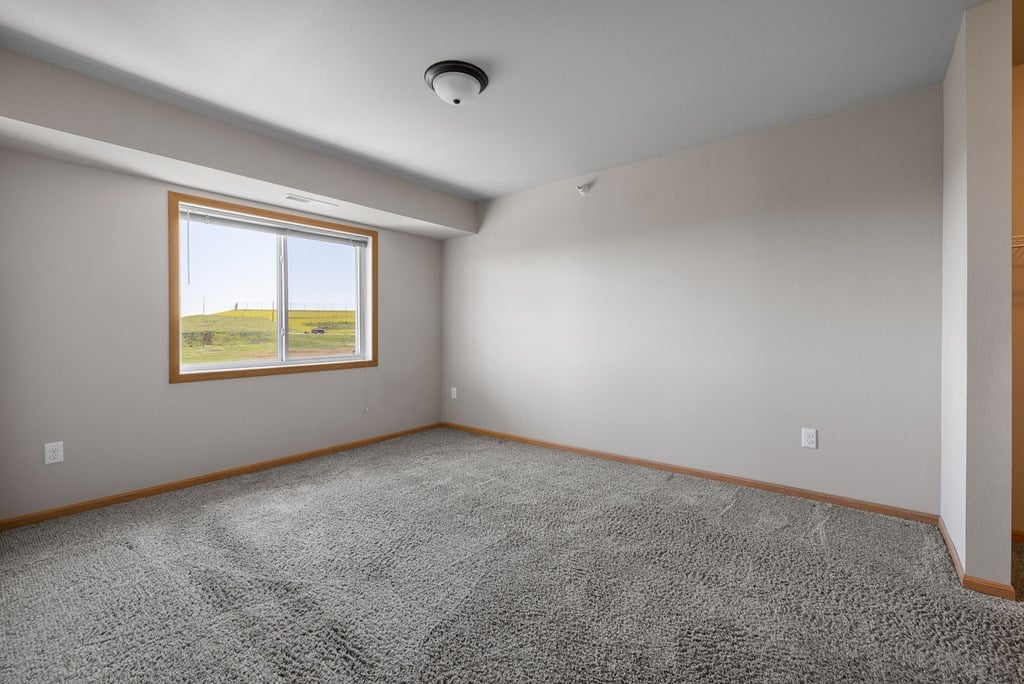 a bedroom with gray walls and a large window